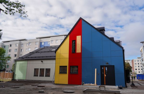 Gavel på spetsigt hus, i blått, gult och rött.